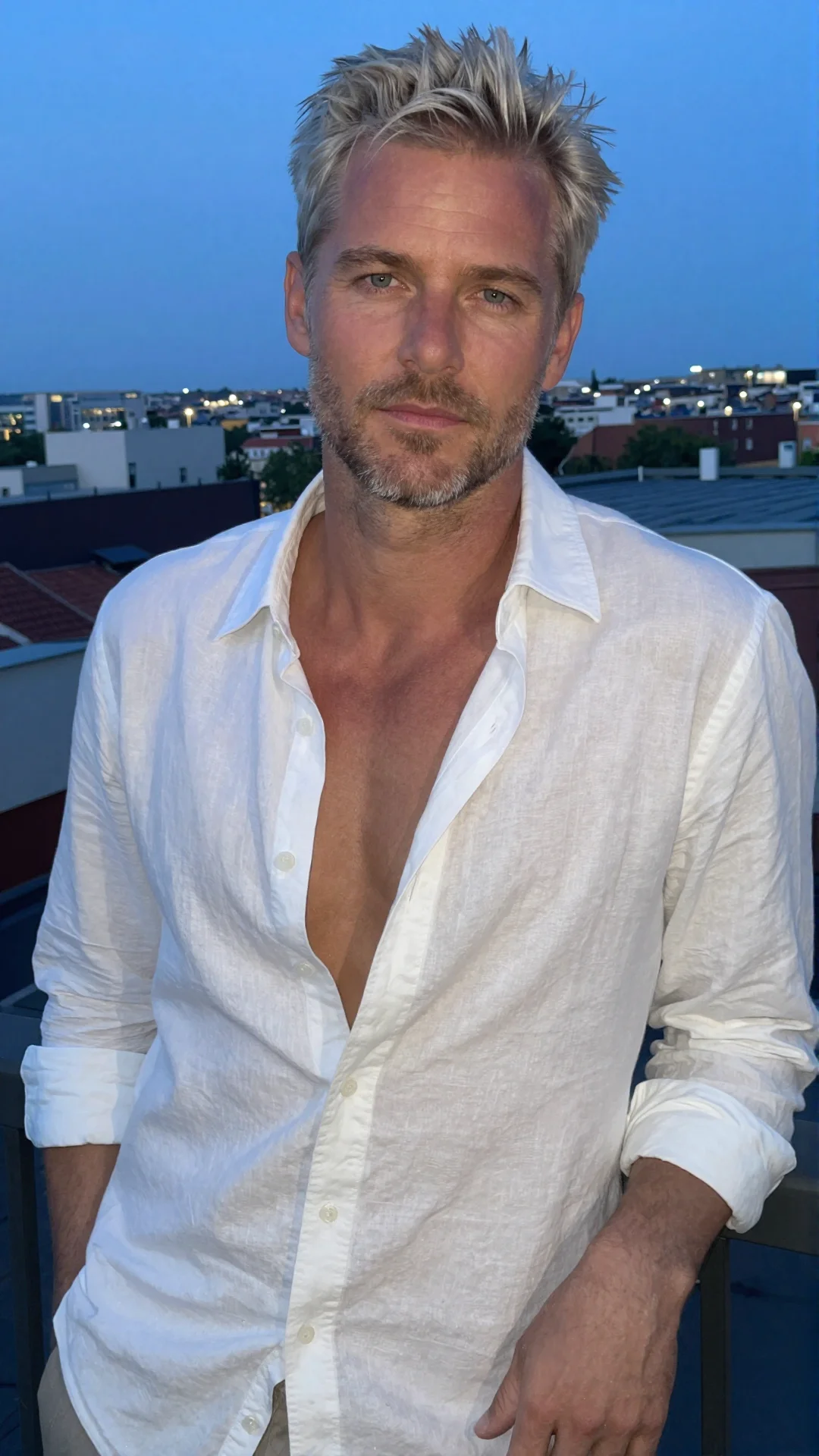Serious Swedish man in an open linen shirt on a rooftop terrace at dusk